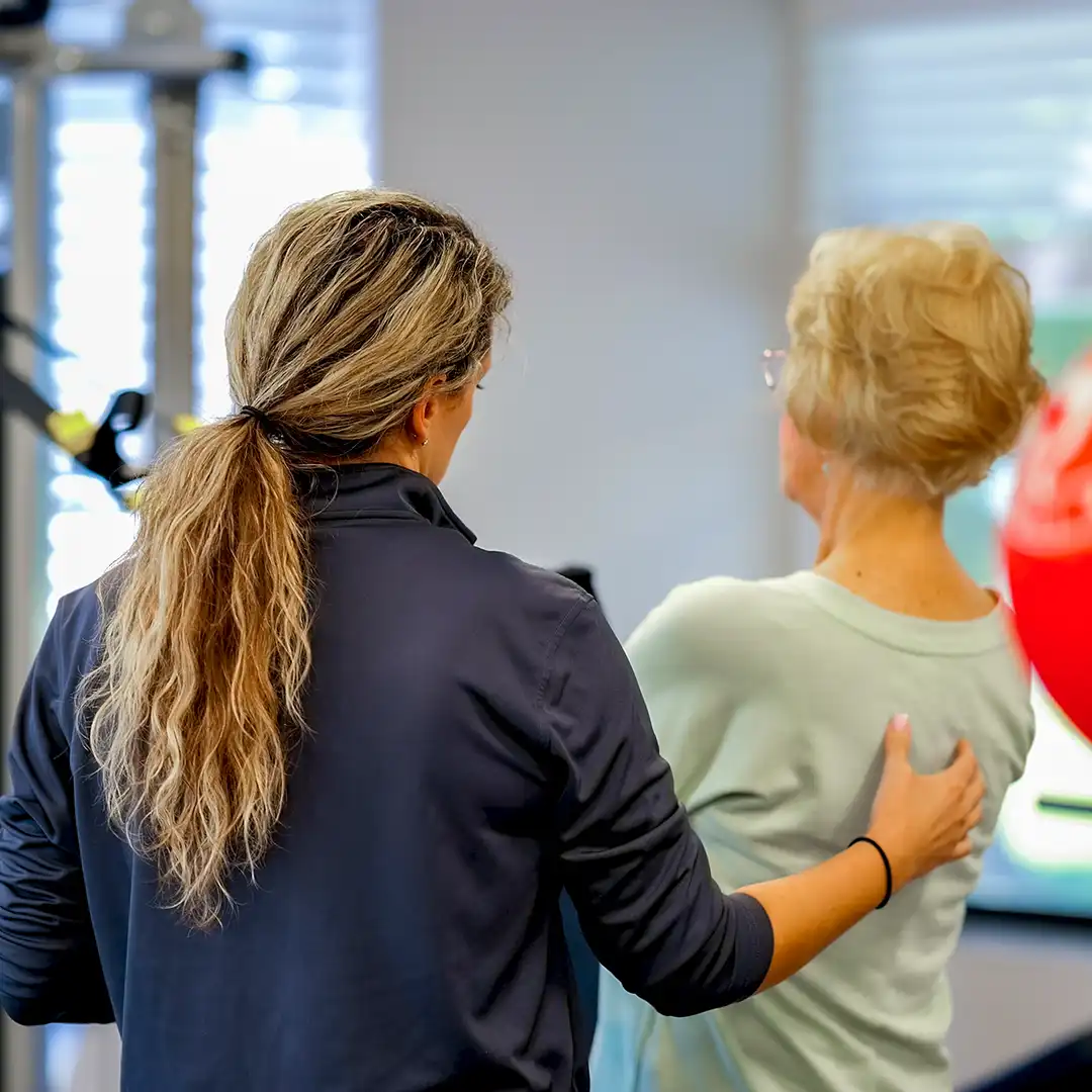 Clinic Director at Total Therapy Florida Punta Gorda location supports patient while doing exercises.