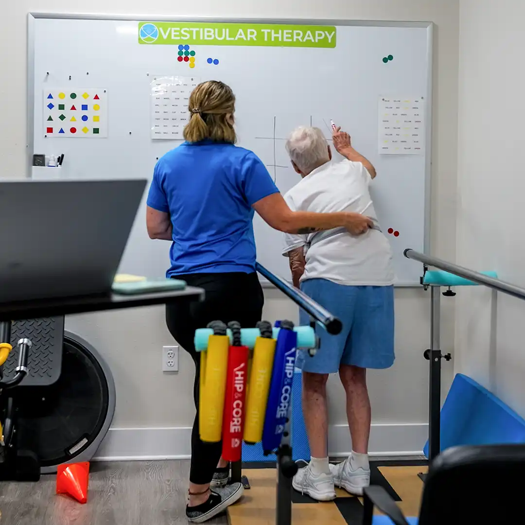 A physical therapy assistant helps a patient with vestibular therapy at the Total Therapy Florida North Port clinic.
